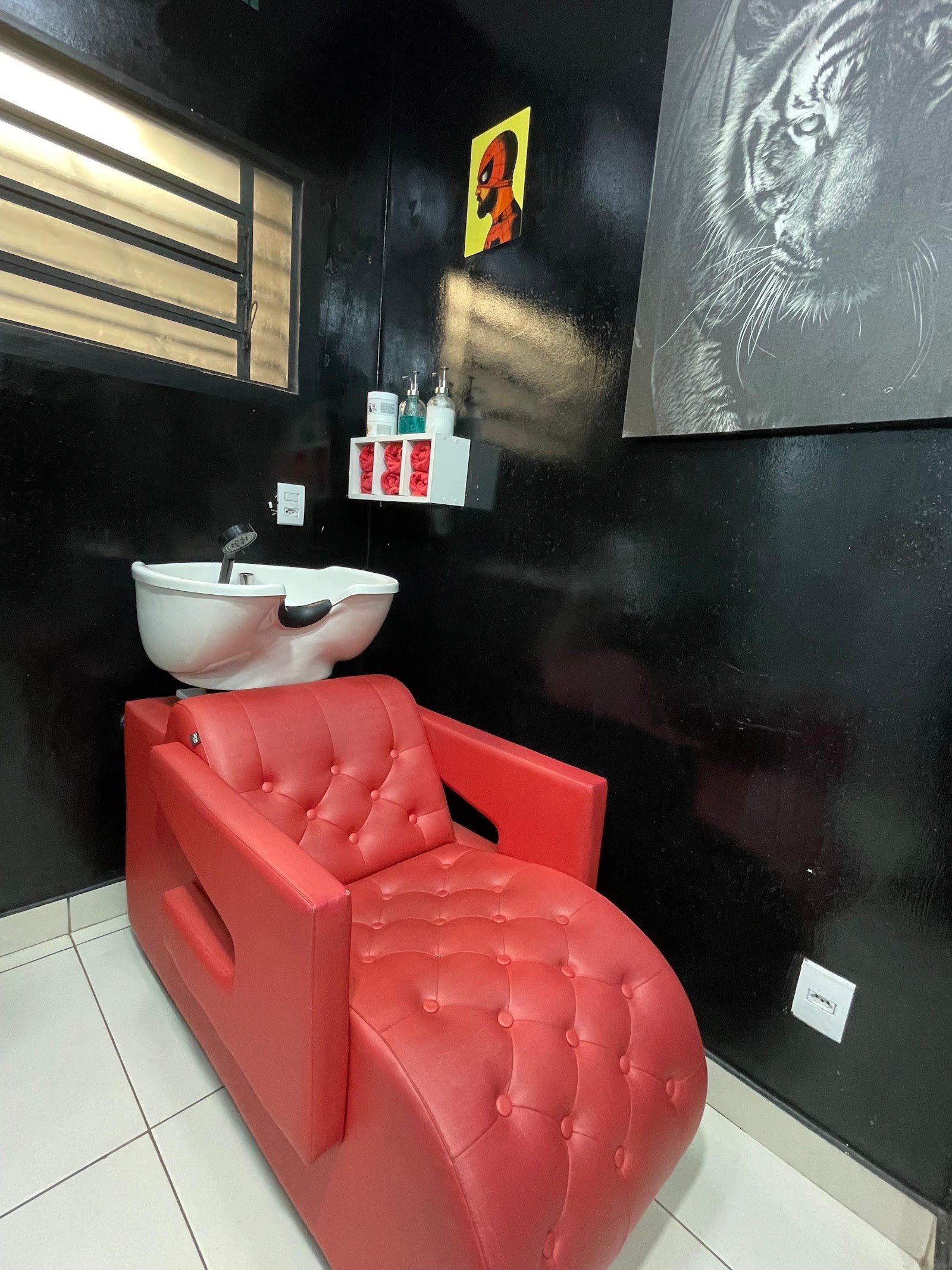 Cadeira lavatório de couro vermelho capitonê na parede preta da Kopolo
