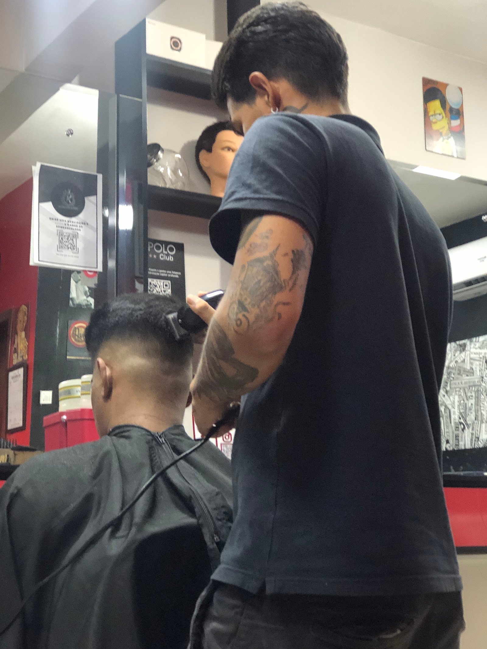 Barbeiro finalizando um degradê na máquina em cliente da Kopolo